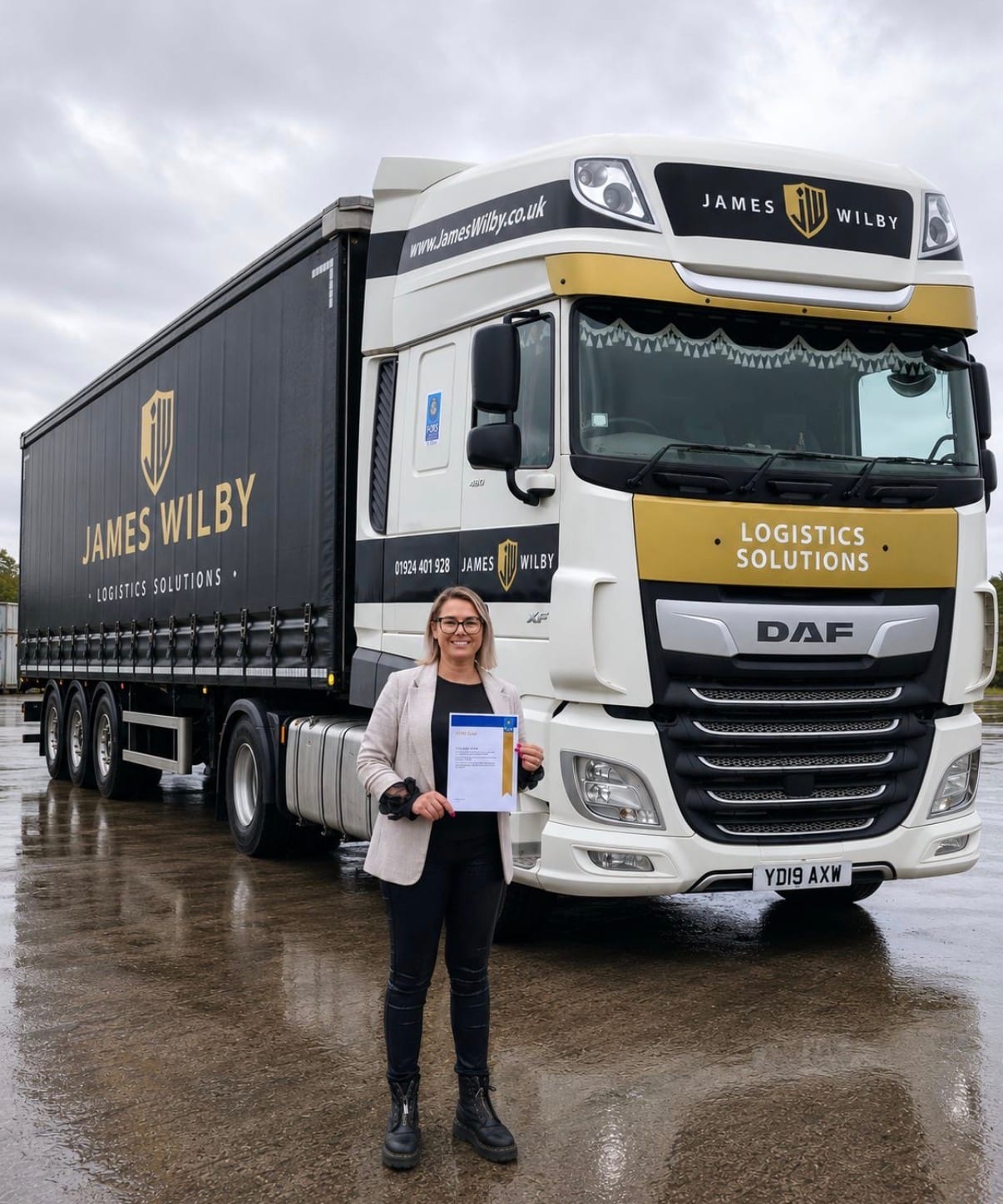 James Wilby colleague holding a FORS Gold certificate in front of a branded DAF HGV